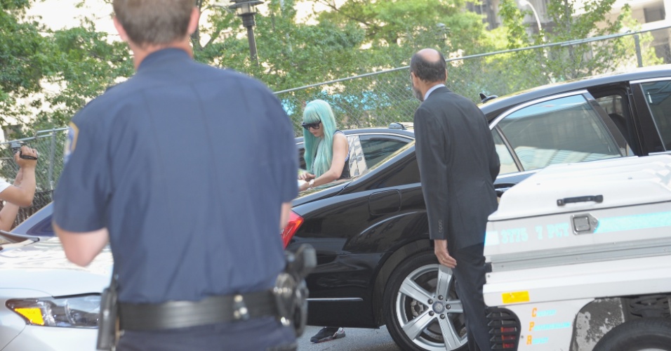 8.jul.2013 - Amanda Bynes chega a um tribunal de Nova York usando uma peruca azul, óculos escuros, calça de moletom e regata. A atriz vai responder às acusações de conduta imprudente, posse de drogas e adulteração de evidências
