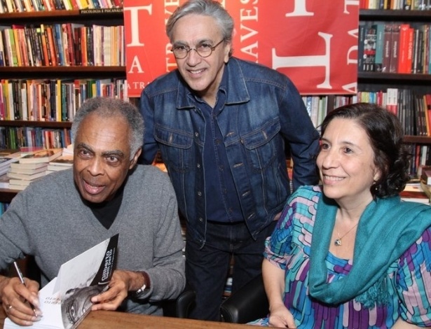 8.jul.2013 - Caetano Veloso posa com Gilberto Gil e a jornalista Regina Zappa durante o lançamento da biografia "Gilberto Bem Perto" em livraria do Rio