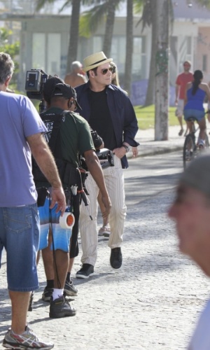 10.jul.2013 - Cercado por seguranças e membros da produção, o ator John Travolta grava comercial de cachaça na praia do Recreio dos Bandeirantes, zona oeste do Rio