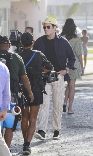 10.jul.2013 - Cercado por seguranças e membros da produção, o ator John Travolta grava comercial de cachaça na praia do Recreio dos Bandeirantes, zona oeste do Rio