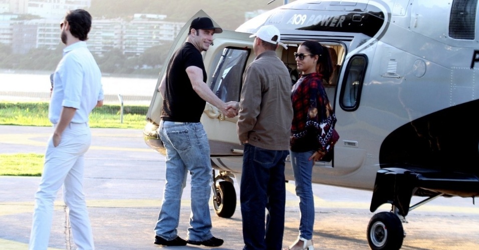 10.jul.2013 - De camiseta e boné pretos, o ator John Travolta cumprimenta fã no heliponto do Pão de Açucar, zona sul do Rio de Janeiro