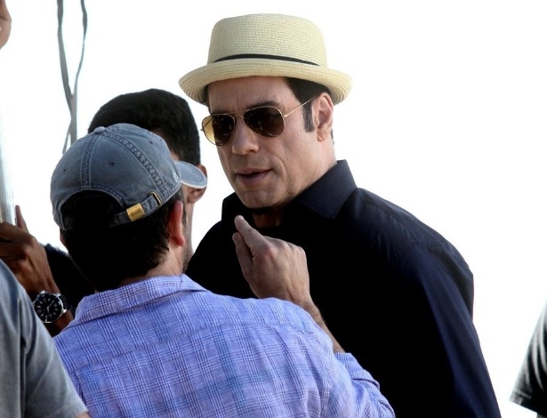 10.jul.2013 - O ator John Travolta conversa com membro da produção durante gravação de comercial de cachaça na praia do Recreio dos Bandeirantes, zona oeste do Rio
