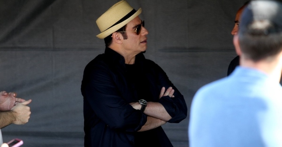 10.jul.2013 - O ator John Travolta conversa com membro da produção durante intervalo na gravação de comercial de cachaça na praia do Recreio dos Bandeirantes, zona oeste do Rio