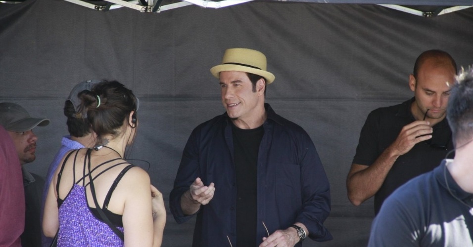 10.jul.2013 - O ator John Travolta conversa com membro da produção durante intervalo na gravação de comercial de cachaça na praia do Recreio dos Bandeirantes, zona oeste do Rio