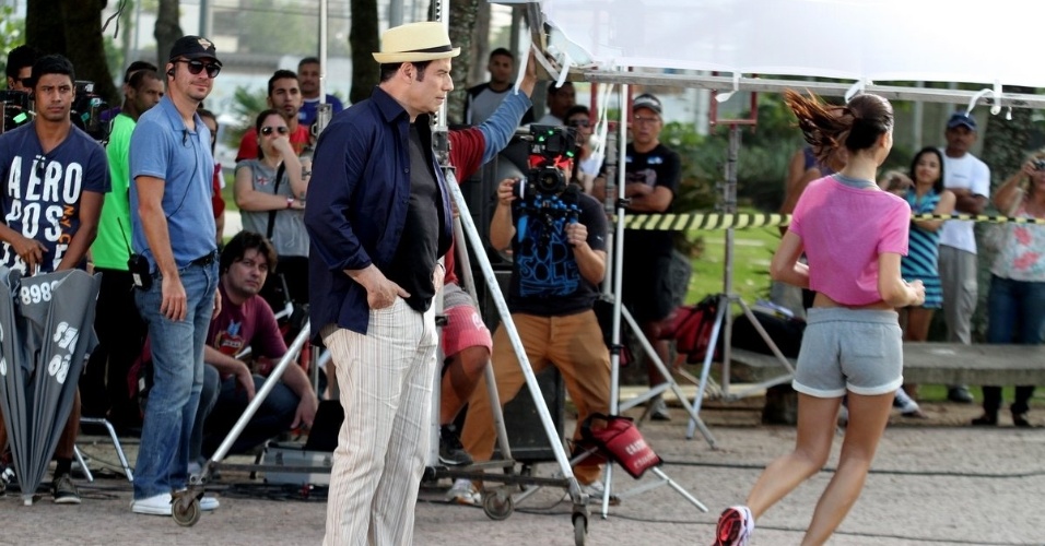 10.jul.2013 - O ator John Travolta olha bumbum de modelo durante gravação de comercial de cachaça no Recreio dos Bandeirantes, no Rio de Janeiro