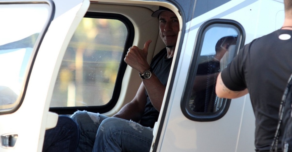 10.jul.2013 - Simpático, o ator John Travolta acena para os fotógrafos de dentro de helicóptero no heliponto do Pão de Açucar, zona sul do Rio de Janeiro