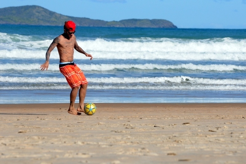 11.jul.2013 -  De férias, Daniel Alves joga bola com crianças na praia de Búzios, na Região dos Lagos, no Rio de Janeiro