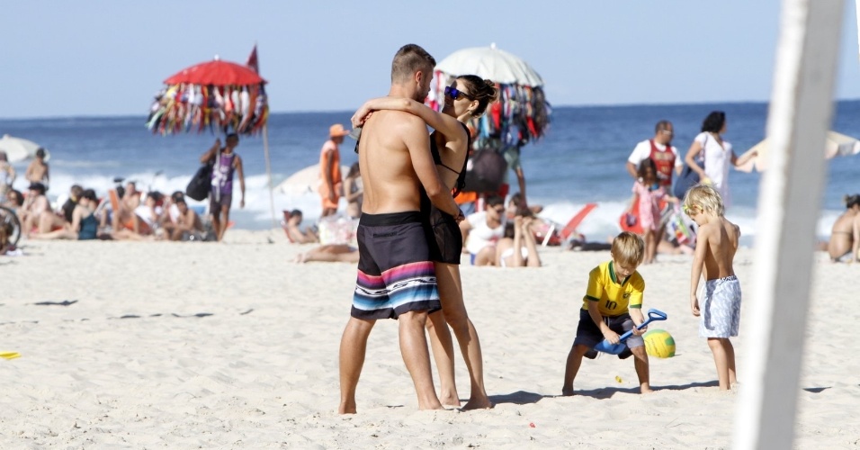 11.jul.2013 - Fernanda Lima e Rodrigo Hilbert curtiram praia no Leblon com os filhos, os gêmeos João e Francisco, de 5 anos. O casal não se intimidou com o paparazzo e trocou beijos e carícias