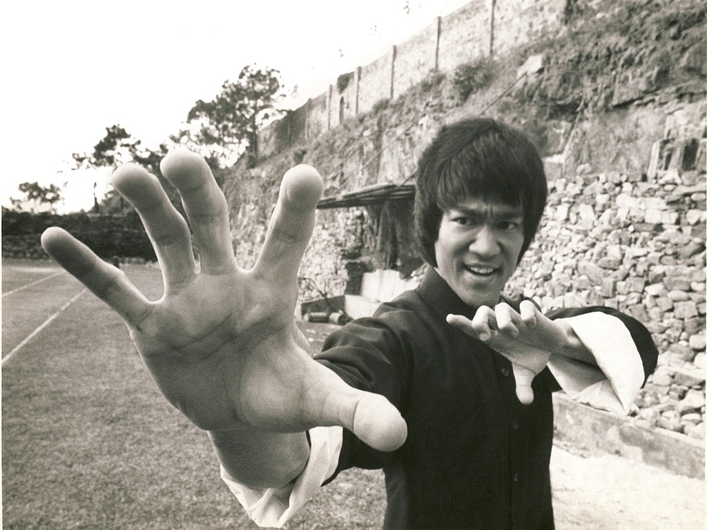 AS LUTAS FORA DAS TELAS - Bruce Lee se tornou conhecido pelo combate dentro e fora das telas. Conforme seu sucesso cresceu, se tornou cada vez mais comum extras e figurantes o desafiarem para lutas reais nos sets batendo os pés em desafio - Reprodução