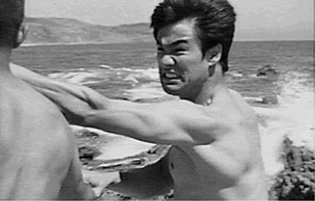 AS LUTAS NAS RUAS NA JUVENTUDE - Hong Kong nos anos 1950 estava tomada por imigrantes fugindo da revolução chinesa, com grande desemprego e violência de gangues nas ruas. Bruce Lee se envolveu em diversas brigas de rua, inclusive contra o filho de um integrante das tríades, a máfia chinesa. Isso que fez com que seus pais resolvessem enviar o filho esquentado para a Califórnia. Na imagem, Bruce Lee praticando com um de seus alunos - Reprodução