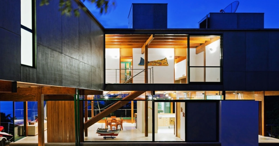 Iluminada à noite, a Casa Embaúba, projetada pela arquiteta Flavia Cancian, é um ponto de luz em meio à natureza de Ilhabela, no litoral paulista. Arandelas e spots presos ao forro criam a atmosfera acolhedora - Nelson Kon/ UOL