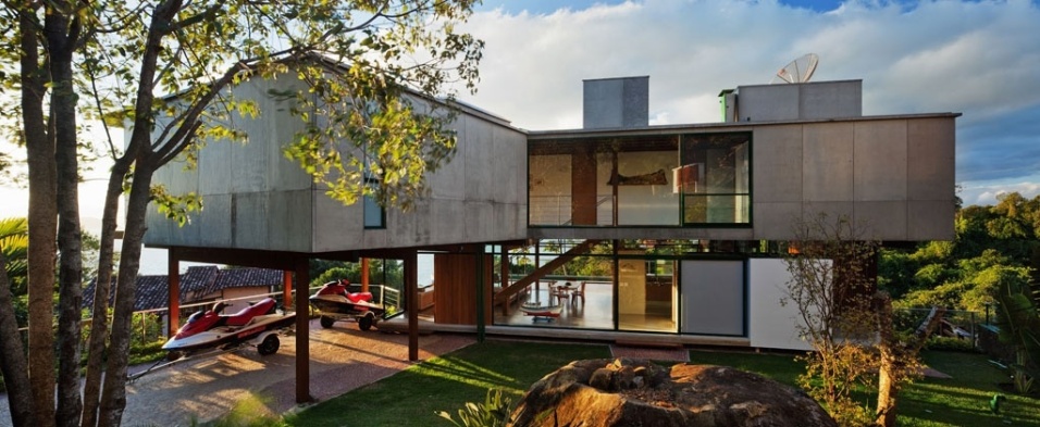 Na face voltada para o jardins da Casa Embaúba, projetada pela arquiteta Flavia Cancian, percebe-se o primeiro pavimento em forma de retângulo e o segundo piso em "V", com um trecho sobre pilotis destinado ao abrigo de barcos e jetskys - Nelson Kon/ UOL