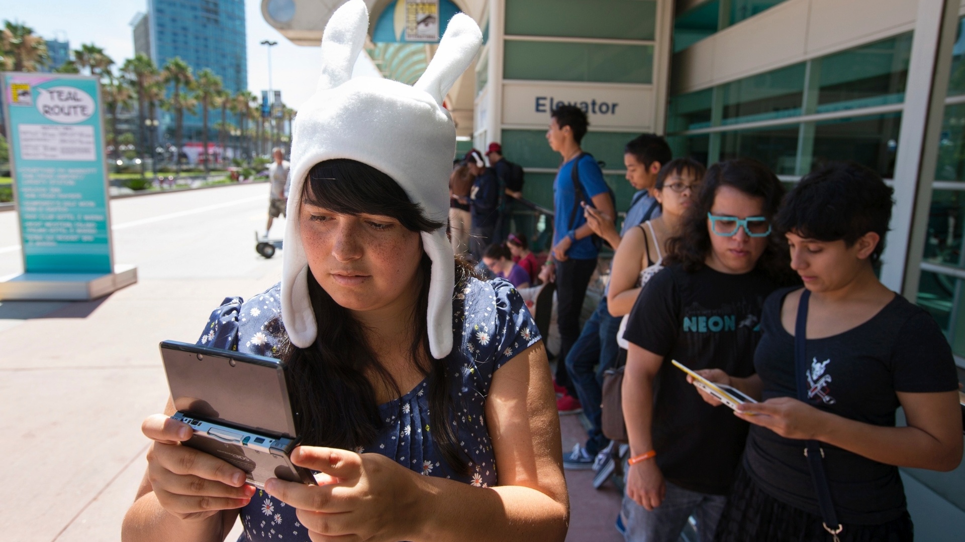 17.jul.2013 - Cosplayer de Fionna, personagem da série "Adventure Time", joga videogame enquanto aguarda a abertura dos portões do Centro de Convenções de San Diego - Fred Greaves/Reuters