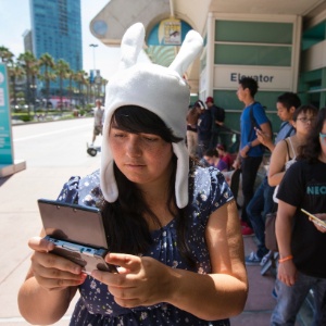 17.jul.2013 - Cosplayer de Fionna, personagem da série "Adventure Time", joga videogame enquanto aguarda a abertura dos portões do Centro de Convenções de San Diego - Fred Greaves/Reuters