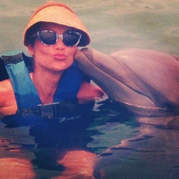 17.jul.2013 - Flávia Alessandra ganha beijo de golfinho em viagem de férias