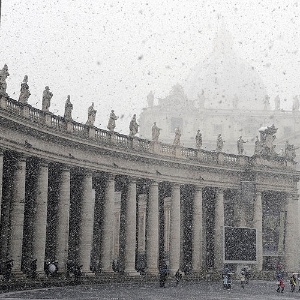Turistas visitam a praça de São Pedro, no Vaticano, em dia de forte nevasca, na região