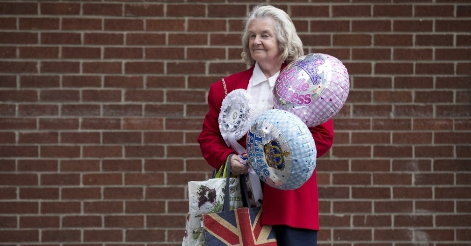 20.jul.2013 - Munida de balões rosa e azul, inglesa aguarda o nascimento do bebê real na porta do hospital St. Mary, em Londres, onde Kate Middleton deve dar à luz a qualquer momento