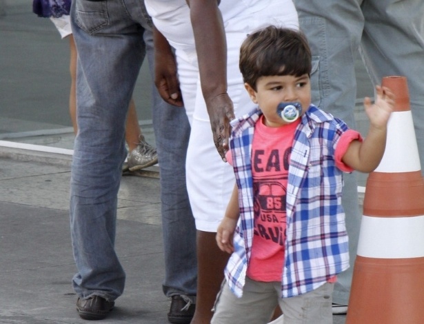 21.jul.2013 - O pequeno Pedro, primogênito de Juliana Paes, acena para os paparazzi ao deixar a maternidade com a babá