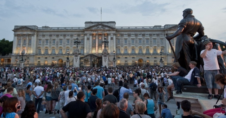 22.jul.2013 - Uma multidão de pessoas tenta se aproximar do portão do Palácio de Buckingham onde um documento assinado pelo médico anuncia o nascimento do príncipe de Cambridge