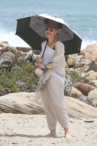 13.jul.2013 - Com um guarda-chuva, a cantora Gwen Stefani aproveita dia na praia com os filhos Kingston e Zuma, em Malibu, na Califórnia, EUA