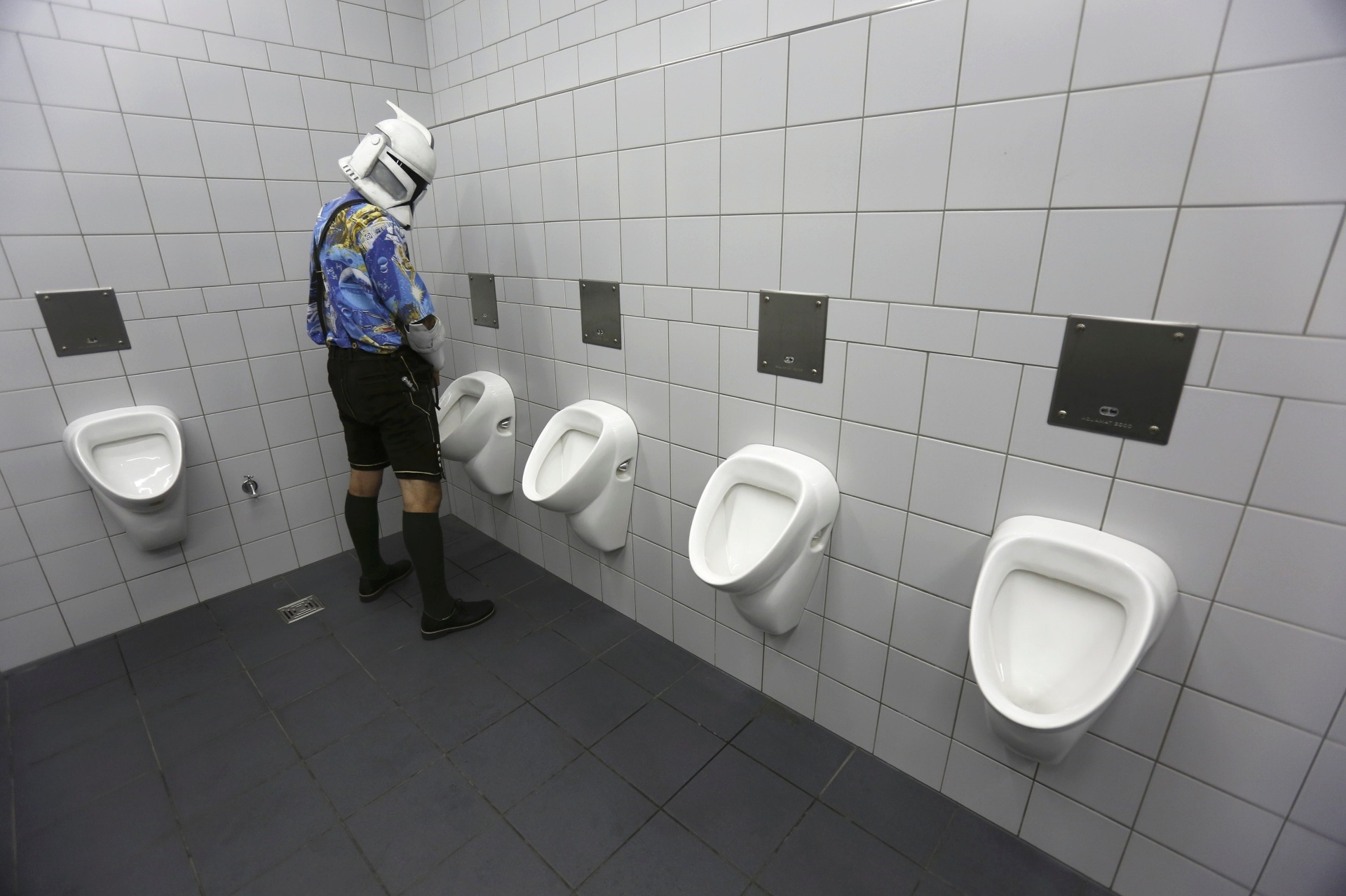 26.jul.2013 - Fã da saga "Star Wars" usa capacete de Clone Trooper e tira foto em banheiro masculino durante a feira "Star Wars Celebration Europe", em Essen, na Alemanha. O evento, que começou nesta quinta-feira (25), vai até domingo (28) - Wolfgang Rattay/Reuters