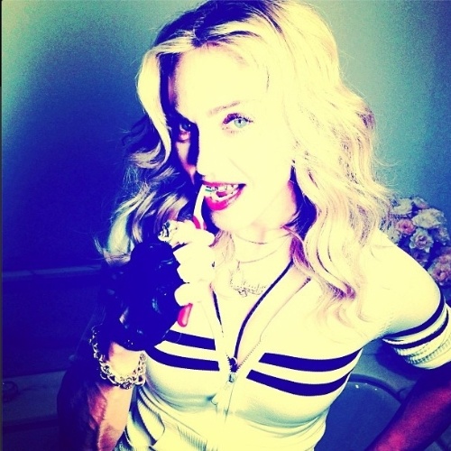 26.jul.2013 - Madonna publica foto em seu perfil no Instagram em que aparece escovando os dentes seu acessório dourado dos dentes. "O trabalho de uma mulher nunca termina!", escreveu a cantora na legenda da foto