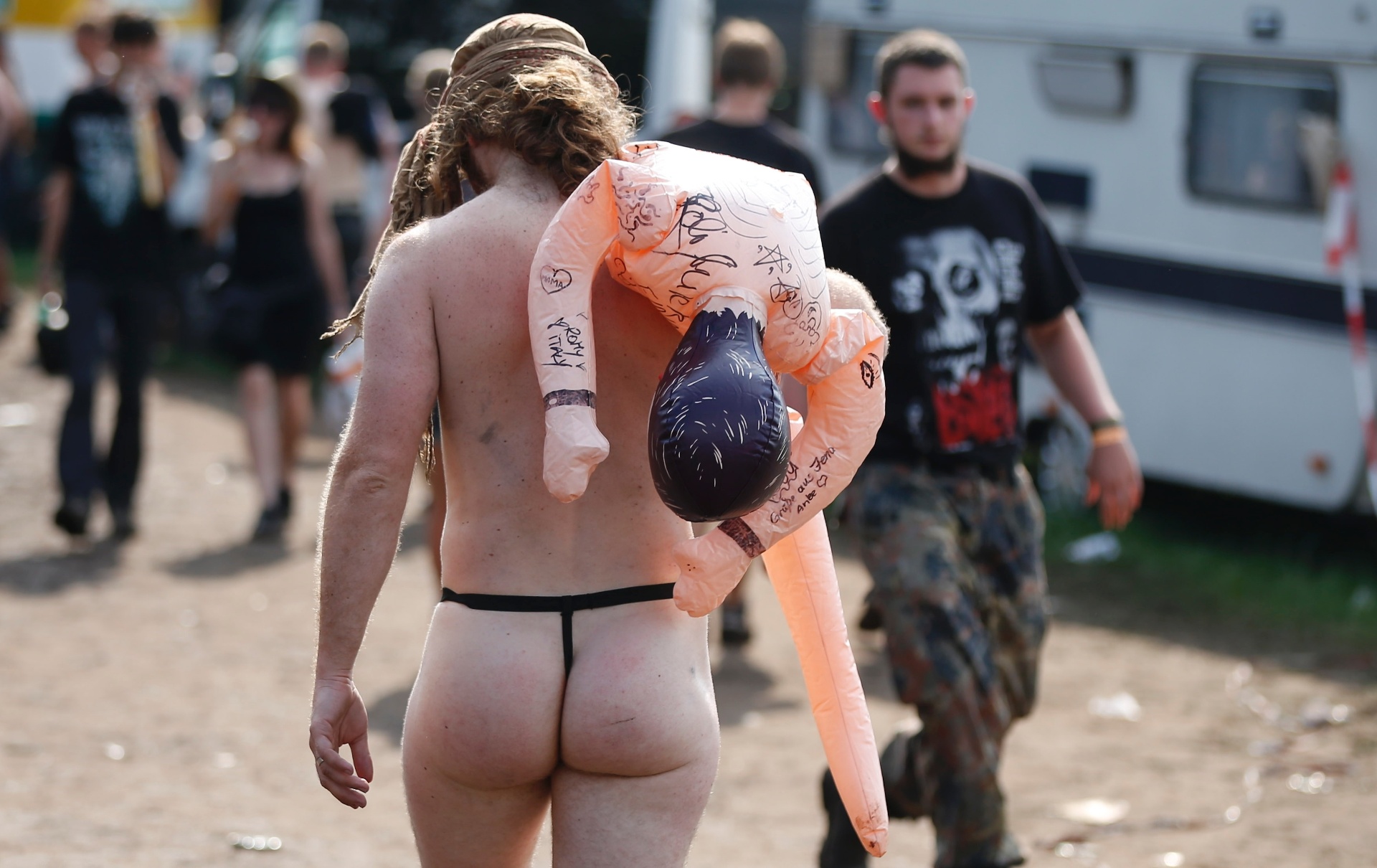 1º.ago.2013 - Metaleiro com figurino inusitado carrega boneca inflável durante o Wacken Open Air - Philipp Guelland/AFP