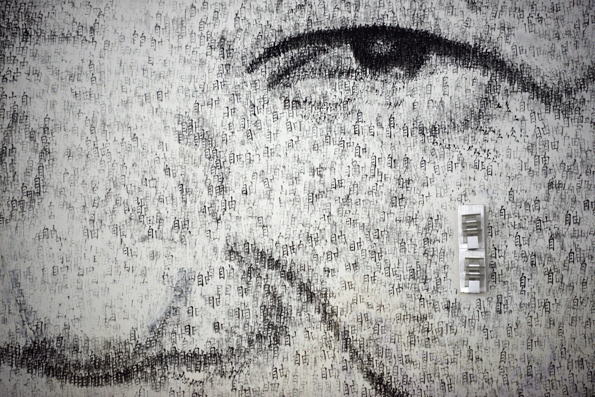 1.ago.2013 - Detalhe do retrato de Nelson Mandela feito pelo artista belga Phil Akashi usando luvas de boxe e carimbos com o ideograma que significa "liberdade" - Peter Parks/AFP