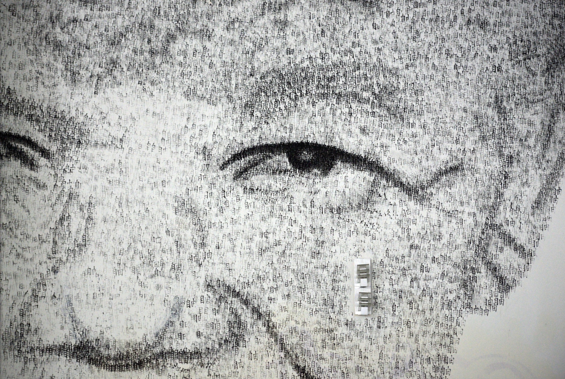 1.ago.2013 - Detalhe do retrato de Nelson Mandela feito pelo artista belga Phil Akashi usando luvas de boxe e carimbos com o ideograma que significa "liberdade" - Peter Parks/AFP