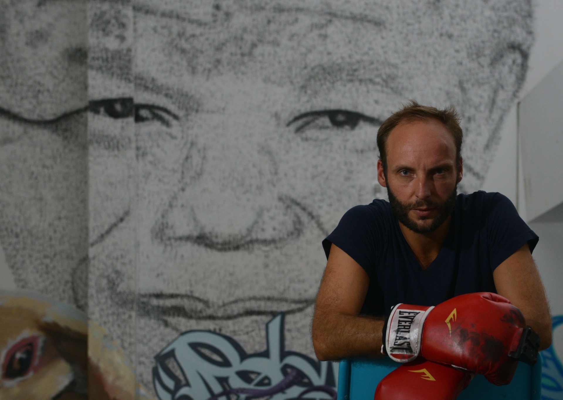 1.ago.2013 - O artista belga Phil Akashi fez um retrato do ex-presidente sul-africano Nelson Mandela dando socos em um muro com uma luva de boxe equipada com um carimbo com o ideograma que significa "liberdade". Akashi, de 34 anos, começou a fazer este monumental retrato de seis metros de altura ao saber que Mandela, hospitalizado desde o início de junho, lutava por sua vida - Peter Parks/AFP