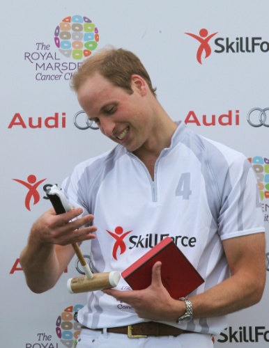 03.ago.2013 - Príncipe William ganha bastão de polo infantil para o filho, príncipe George, em evento beneficente em Coworth Park, no sul da Inglaterra
