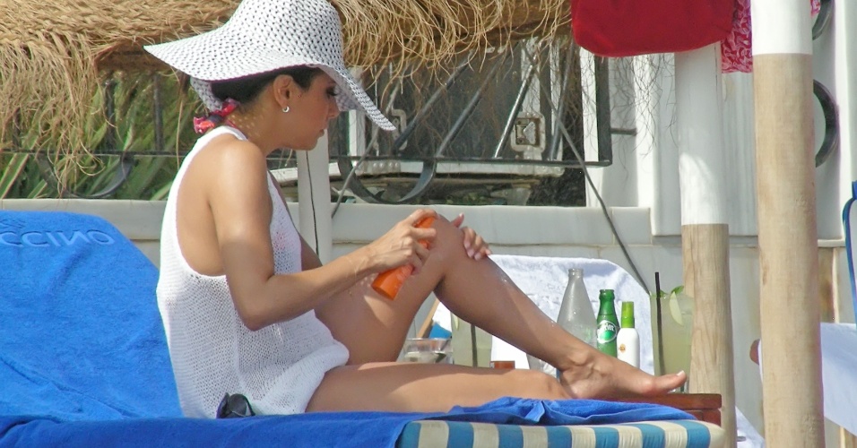 4.ago.2013 - Eva Longloria passa protetor solar nas pernas durante dia de praia em Marbella, na Espanha. A atriz estava acompanhada pelo namorado, Ernesto Arguello