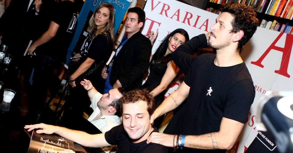 8.ago.2013 - Gregório Duvivier recebe uma massagem de João Vicente Carvalho durante a sessão de autógrafos