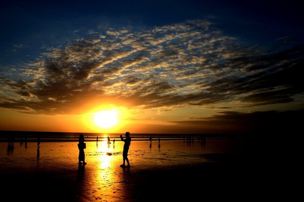 Pessoas caminham pela praia Kuta em Dempassar na ilha de Bali, na Indonésia (09/08/2013) - Sonny Tumbelaka/AFP