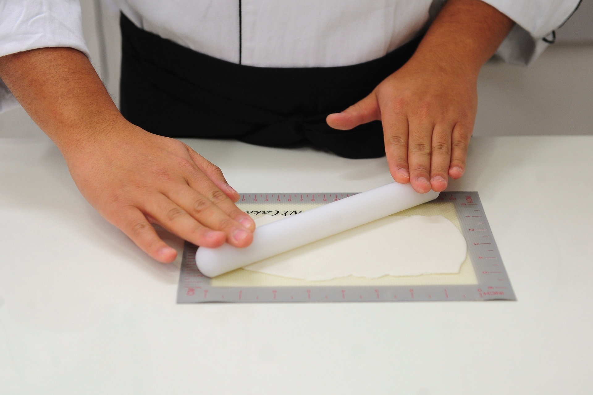 Abra a pasta americana branca com a ajuda de um rolo, sobre o tapete culinário, até que ela fique fina e lisa - Junior Lago/UOL