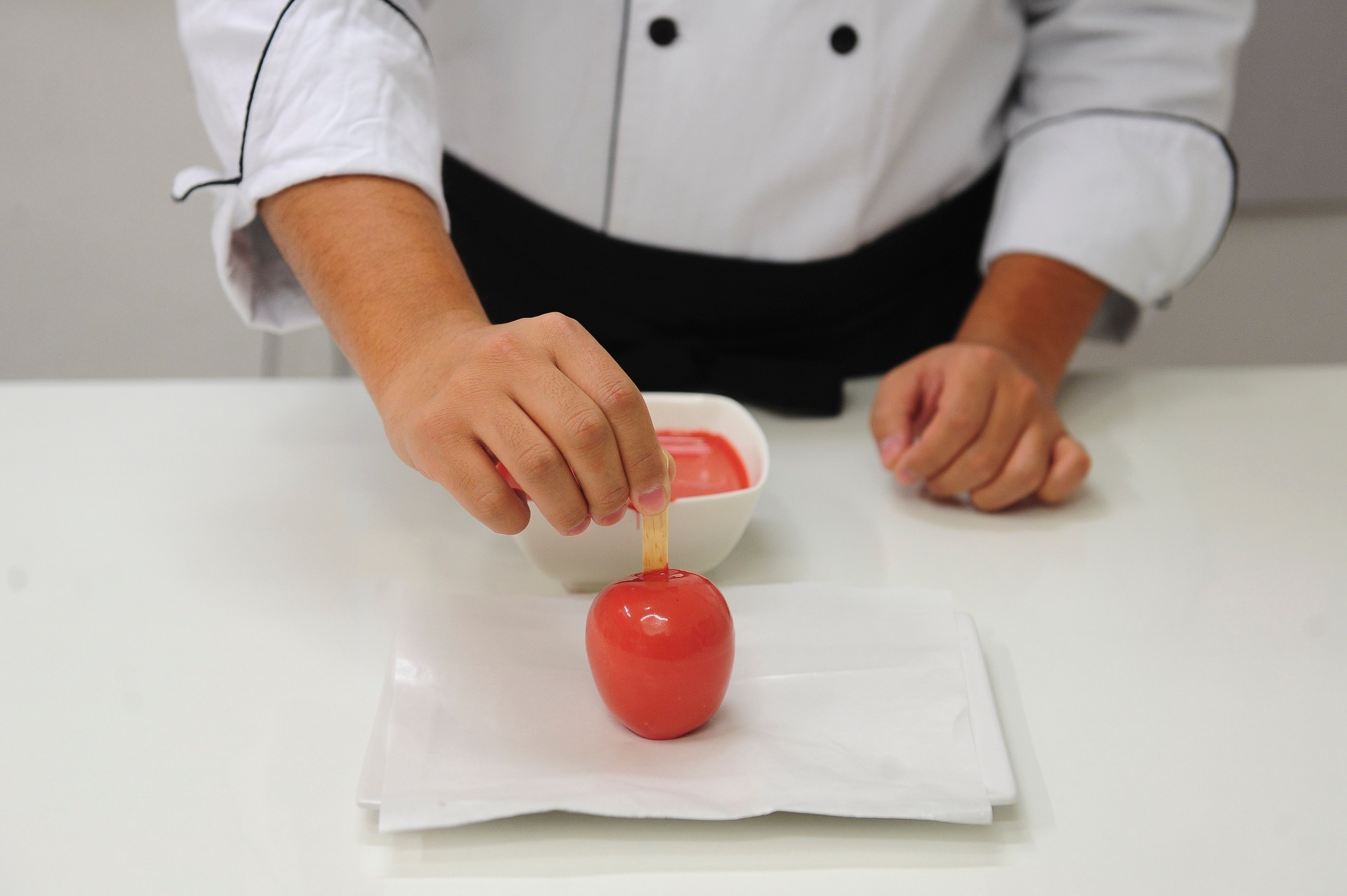 Espere escorrer o excesso e coloque a maçã para secar sobre um pedaço de papel-manteiga, para evitar que o chocolate grude e rache. Reserve e espere secar por pelo menos 5 minutos - Junior Lago/UOL