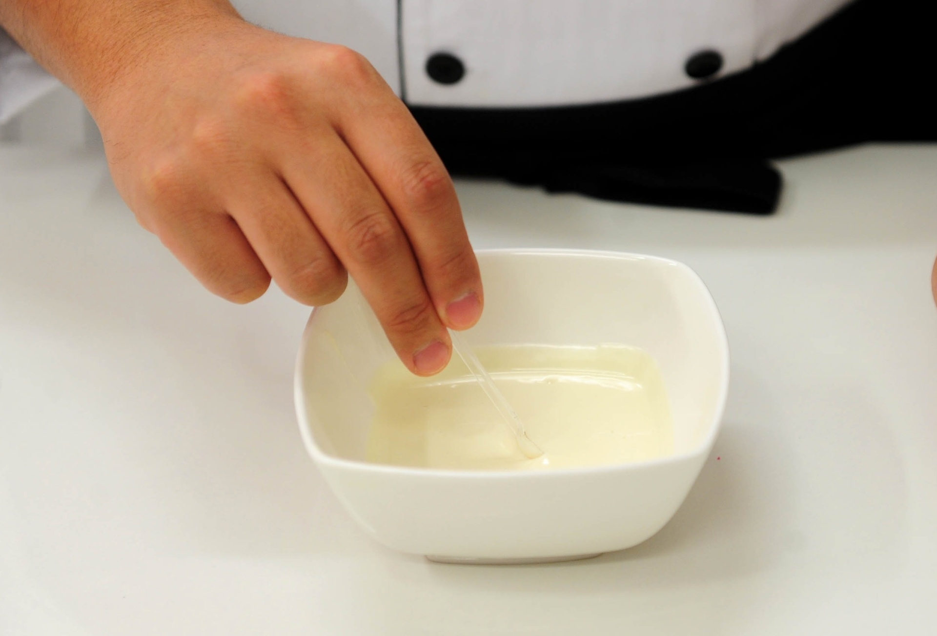 Numa tigela de vidro ou cerâmica pequena, coloque o chocolate em pastilhas e leve ao micro-ondas para derreter. A cada 30 segundos abra o micro-ondas e mexa o chocolate, até que o creme fique homogêneo, sem pedaços. Então, retire e mexa por mais 1 minuto, para que o chocolate esfrie um pouco. Em seguida, adicione o corante laranja, aos pouquinhos. Mexa até a cor ficar homogênea - Junior Lago/UOL