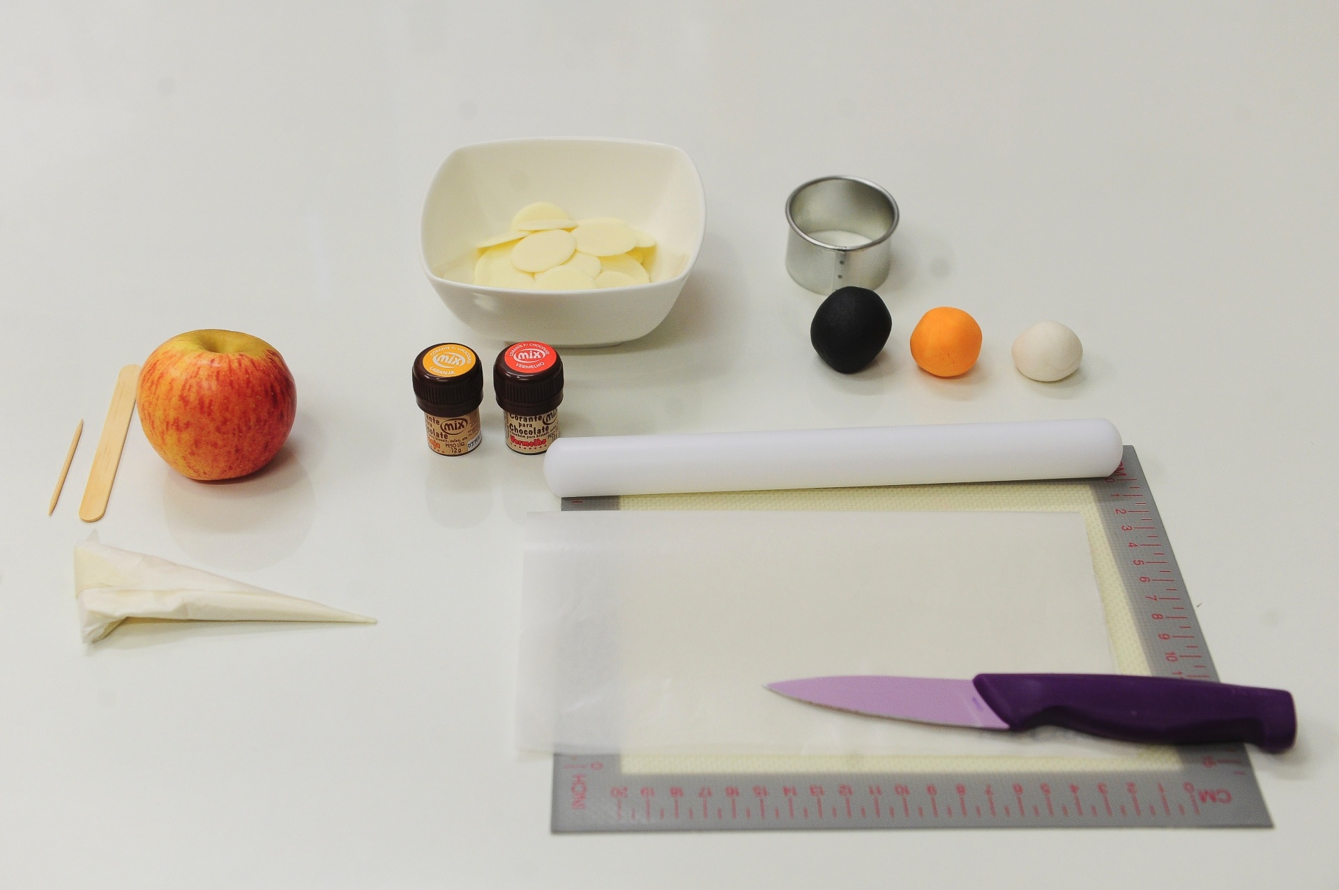 Para fazer esta maçã personalizada, você vai precisar de: 1 maçã, 400 g de chocolate branco em pastilhas, 1 colher de café de corante laranja para chocolate, 1 colher de café de corante vermelho para chocolate, 100 g de pasta americana preta, 100 g de pasta americana laranja e 100 g de pasta americana branca - Junior Lago/UOL