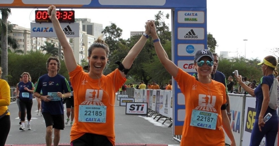 18.ago.2013 - As atrizes Fernanda Pontes e Monique Alfradique comemoram chegada na meia-maratona do Rio