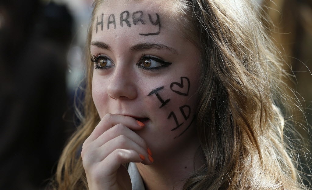 20.ago.2013 - Tayla Seaborne, fã do One Direction, espera a chegada da banda para a estreia mundial do filme "One Direction: This Is Us" na Praça Leicester, no centro de Londres. Na sua testa, ela escreveu o nome "Harry", um dos membros da boyband - REUTERS/Suzanne Plunkett