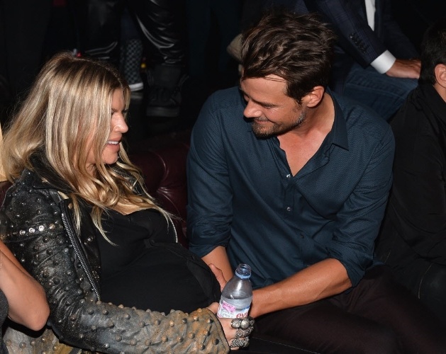 20.ago.2013 - A cantora Fergie recebe um afago na barriga do marido, o ator Josh Duhamel, durante festa após a première de "Scenic Rout, em um hotel em Hollywood