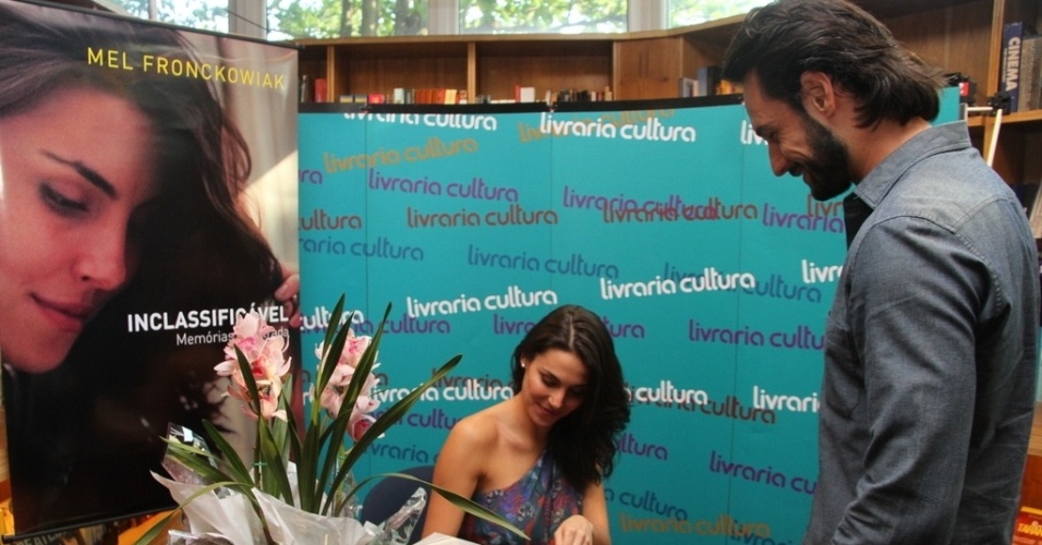 24.ago.2013 - Mel Fronckowiak autografa um exemplar para o namorado, o ator Rodrigo Santoro