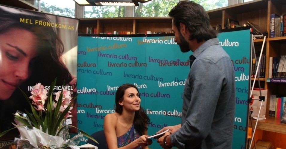 24.ago.2013 - Mel Fronckowiak entrega o livro autografado para o namorado, Rodrigo Santoro