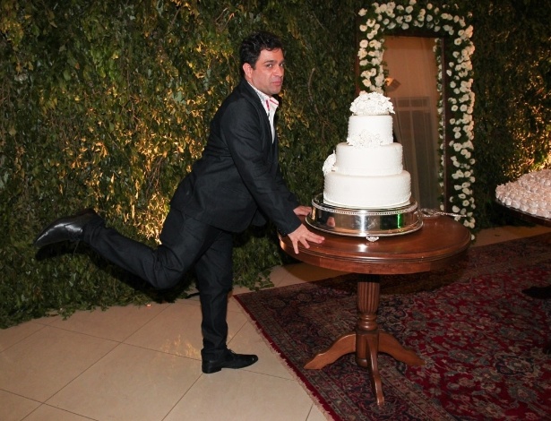 24.ago.2013 - Evandro Santo faz graça ao lado do bolo de casamento de Karina Sato, irmã de Sabrina, que se casou neste sábado em Penápolis (SP)