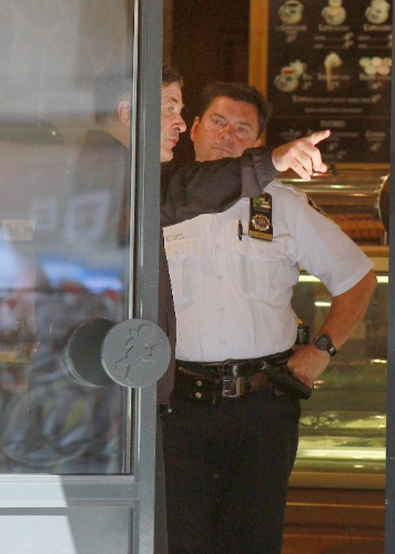 27.ago.2013 - Alec Baldwin fala com a polícia após brigar com fotógrafo em rua de Nova York. O ator partiu para cima do paparazzo ao ser abordado por ele enquanto passeava com a mulher em rua de Nova York