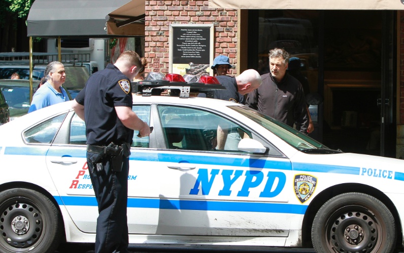 27.ago.2013 - Polícia chega e aparta a briga entre Alec Baldwin e um fotógrafo em rua de Nova York. O ator imobilizou o paparazzo após ser abordado por ele em rua de Nova York