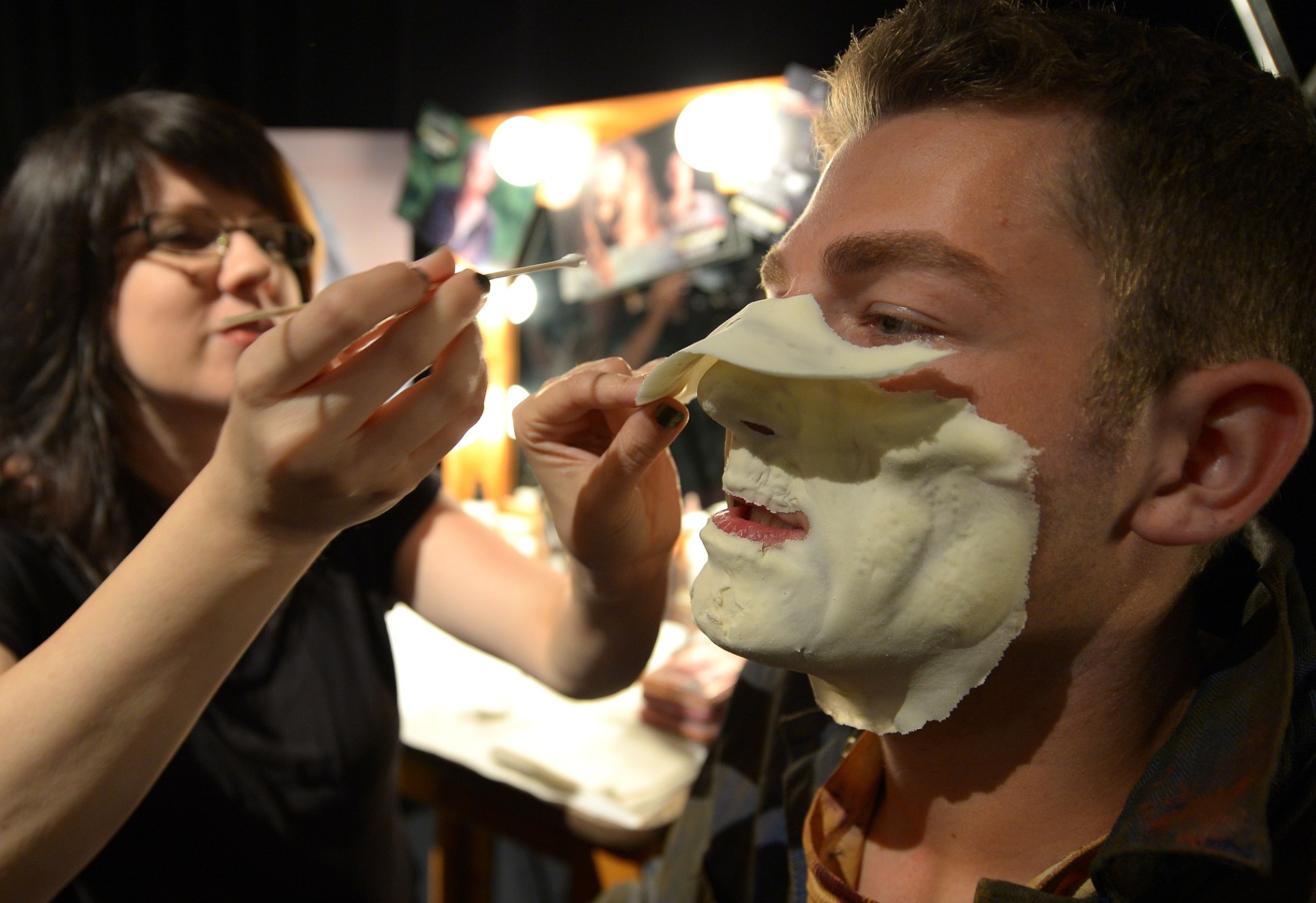 27.ago.2013 - Profissional de maquiagem prepara ator para a noite de apresentação do Halloween Horror Nights, na Califórnia - Joe Klamar/AFP