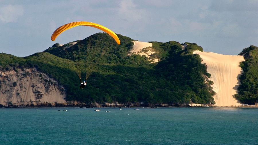 Praticante de parapente sobrevoa a praia de Ponta Negra, a mais turística de Natal (RN). Ao fundo, o Morro do Careca, cartão postal da capital potiguar - Canindé Soares/UOL