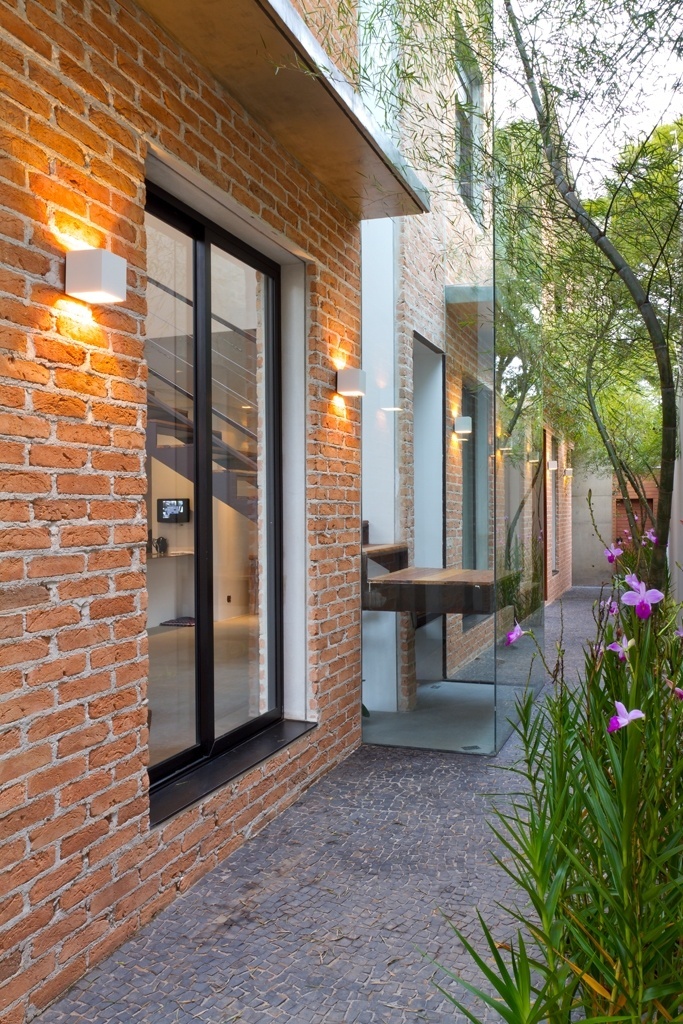 A escada de acesso ao pavimento superior é um dos destaques da Casa Urbana, projetada pela arquiteta Paula Bittar. Para não ocupar espaço no living e permitir que as pessoas passassem por baixo da estrutura, a profissional colocou o patamar para fora da casa, envolto por uma caixa de vidro (à dir.). A estrutura da escada mescla as madeiras de demolição peroba e canela - Sergio Scripilliti/ Divulgação