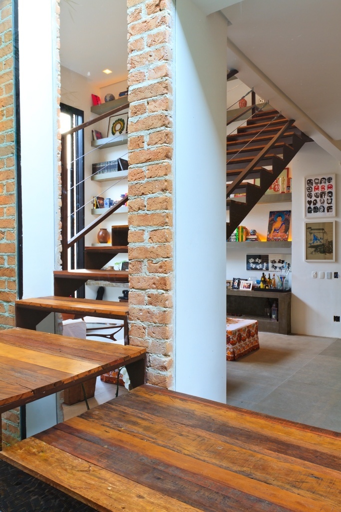 A escada de acesso ao pavimento superior é um dos destaques da Casa Urbana, projetada pela arquiteta Paula Bittar. Para não ocupar espaço no living e permitir que as pessoas passassem por baixo da estrutura, a profissional colocou o patamar para fora da casa, envolto por uma caixa de vidro. A estrutura da escada mescla as madeiras de demolição peroba e canela - Sergio Scripilliti/ Divulgação